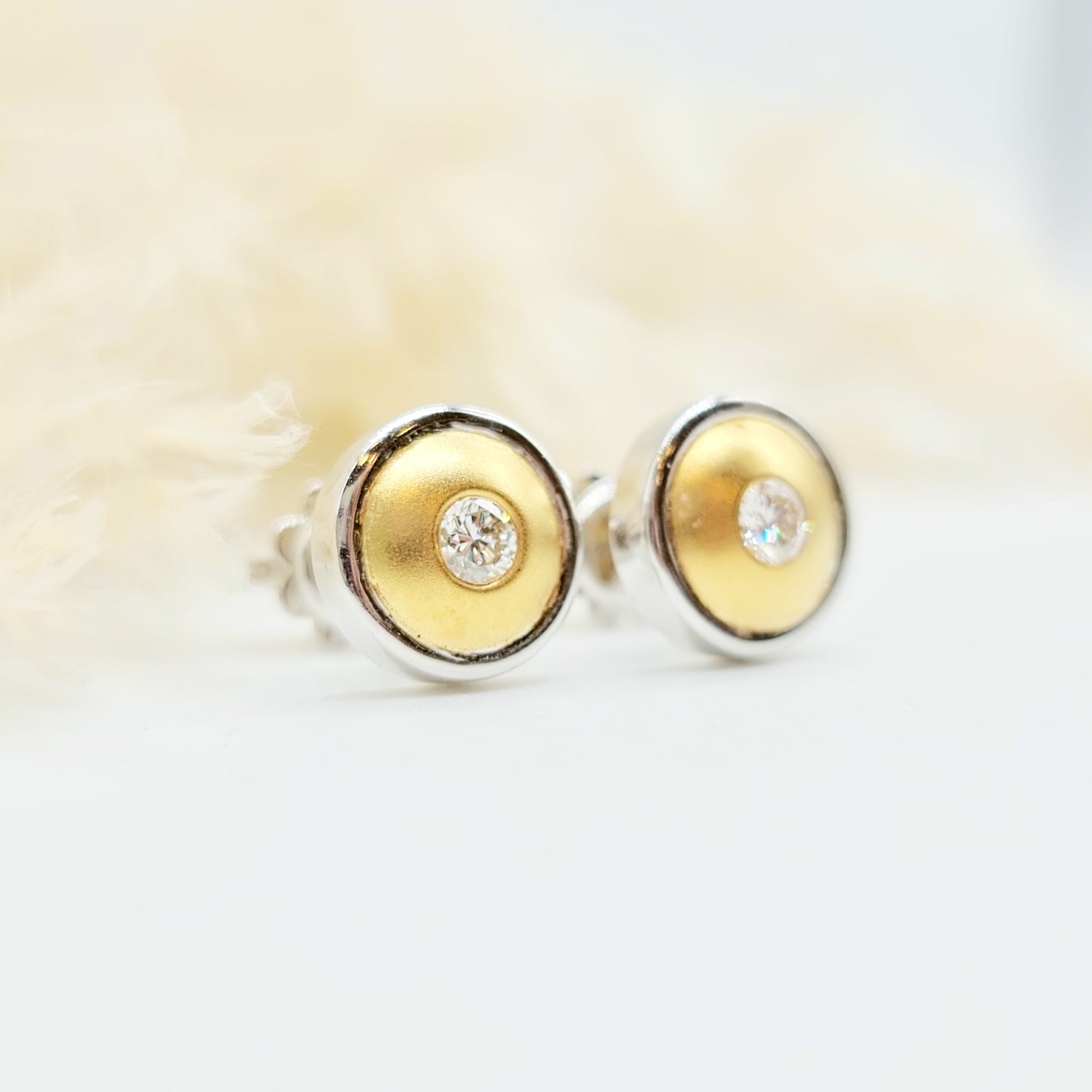 Erwecken Sie die Sonne in sich mit diesen luxuriösen Ohrsteckern aus 750er Weiß- und Gelbgold! Mit insgesamt 0,30 Karat Brillanten, spürbarem Gewicht und sicherem Verschluss sind sie nicht nur hochwertig verarbeitet, sondern auch ein echter Blickfang. Der Kreis aus Weiß- und Gelbgold strahlt wie die Sonne selbst. Durchmesser: 10mm.