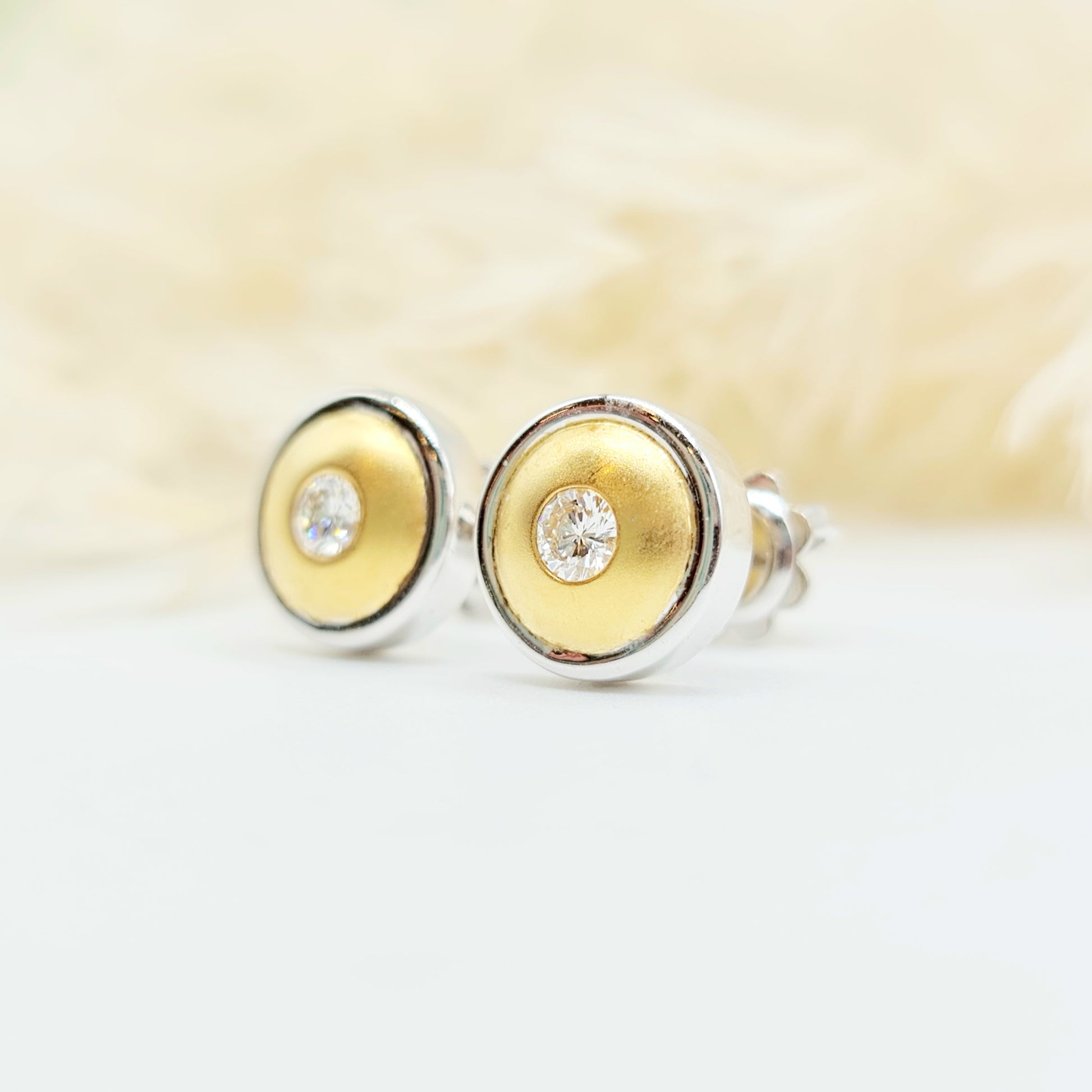 Erwecken Sie die Sonne in sich mit diesen luxuriösen Ohrsteckern aus 750er Weiß- und Gelbgold! Mit insgesamt 0,30 Karat Brillanten, spürbarem Gewicht und sicherem Verschluss sind sie nicht nur hochwertig verarbeitet, sondern auch ein echter Blickfang. Der Kreis aus Weiß- und Gelbgold strahlt wie die Sonne selbst. Durchmesser: 10mm.